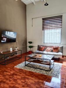 a living room with a couch and a table at Kambal Peregrino in Mérida