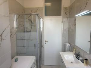 a white bathroom with a shower and a sink at Vivi IL RIFUGIO NEL CIELO in Bologna