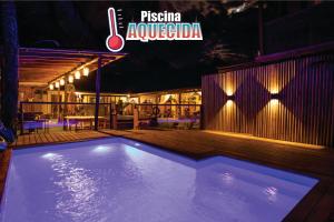 蜜岛Maré Alta - Guest House的夜晚的游泳池，上面挂着“fiesta napaagogoria”的标志