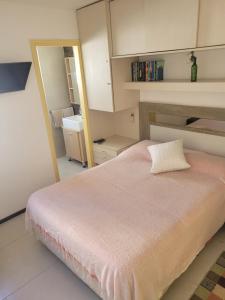 a bedroom with a large bed and a mirror at APARTAMENTO 1 DORMITORIO EN PUNTA DEL ESTE in Punta del Este