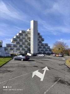 un parking avec une flèche de stationnement devant un bâtiment dans l'établissement Appartement Iris, au Coq