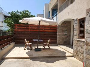 a table and two chairs under an umbrella on a patio at Lovely ground floor apartment with BBQ in Aglantzia