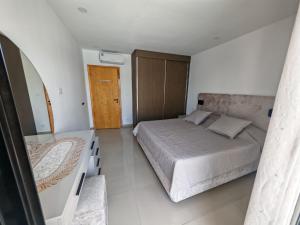 a small bedroom with a bed and a mirror at Dar Ayla à DJERBA houmt souk in Houmt Souk +15 photos