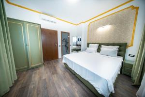 布加勒斯特Hotel Artegianale Boutique的一间卧室，里面有一张铺着白色床单的大床。