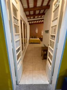 a hallway with open doors with a bed in the background at Villa Tequila-Casa Frida in Alta Gracia