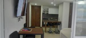 a small living room with a table and a kitchen at Apartamento alto verde in Melgar