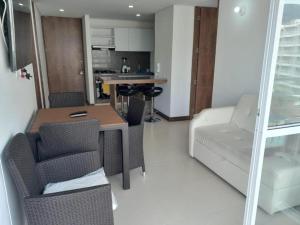 a living room with a table and chairs and a couch at Apartamento alto verde in Melgar