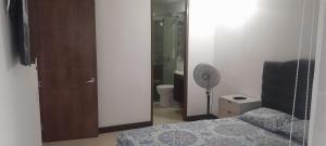 a bedroom with a bed and a shower and a fan at Apartamento alto verde in Melgar