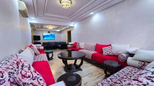 a living room with a red couch and a table at Spacious & chic - 3 min from Casa City Finance " CFC " in Casablanca