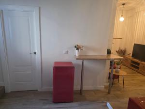 a red refrigerator in a room with a table at La Remonta in Santander
