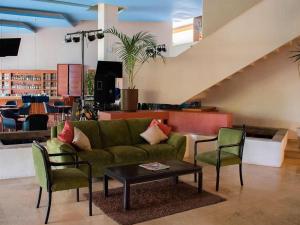 a living room with a green couch and chairs at Grand Cantalagua Hotel Morelia, BW Signature Collection in Morelia