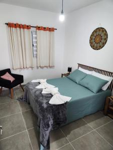 a bedroom with a bed and a table with towels on it at Casa da Vila in Monte Alegre do Sul