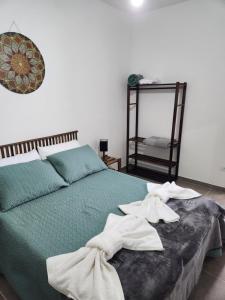 a bedroom with a green bed with towels on it at Casa da Vila in Monte Alegre do Sul +7 photos