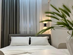 a bedroom with a bed and a potted plant at Aloju Rooms in Vlorë