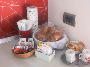 un mostrador con un montón de comida y una cesta de comida en B&B LA Sara INDIRIZZO VIA SERAFINO CALINDRI N 1, en Bolonia 4 fotos más