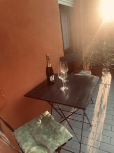Una botella de vino y dos copas en una mesa en B&B LA Sara INDIRIZZO VIA SERAFINO CALINDRI N 1, en Bolonia