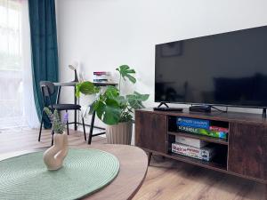 een woonkamer met een flatscreen-tv en een tafel bij #PodZamek in Wałbrzych