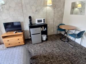 a room with a bed and a table and a microwave at Silver Lakes Inn in Hayden