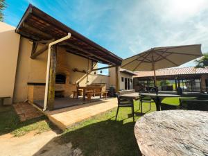 a patio with a table and an umbrella at Espaço Ranchão com Piscina em São Pedro - SP in São Pedro