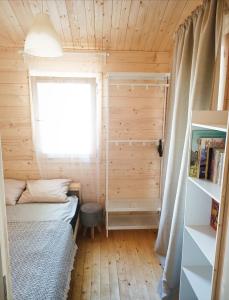 a small room with a bed and a window at Dreamholia in Jastarnia