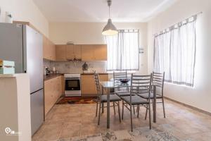 a kitchen with a table and chairs and a refrigerator at Omiros - Spacious Seaside House At Poros in Poros