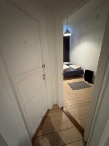 a hallway with a door and a bed in a room at City heart guesthouse in Oslo