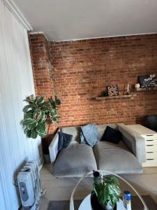 a living room with a brick wall and a couch at City heart guesthouse in Oslo