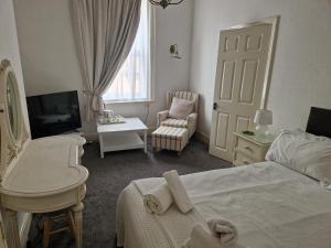 a bedroom with a bed and a chair and a television at Southcliffe hotel in Bridlington