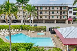 an aerial view of a hotel with a pool and palm trees at Pool Access Relaxing Naples Bay Extended Stay! in Naples