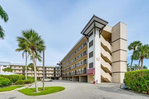 a building with palm trees in front of it at Pool Access Relaxing Naples Bay Extended Stay! in Naples