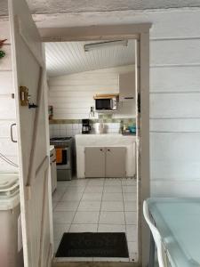 an open door to a kitchen with a stove and sink at Rafaelas in Le Gosier