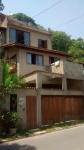 a house with a wooden gate and a garage at Suite no Paraiso! Uma experiência única de paz! in São Vicente +2 photos