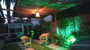 eine Terrasse mit zwei Stühlen unter einem Dach bei Nacht in der Unterkunft Sol y Playa in Mar del Plata