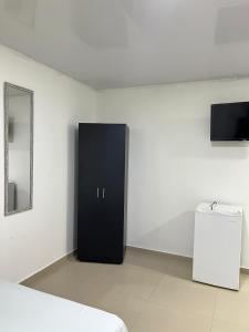 Un armario negro en una habitación blanca con un espejo. en Tropical Dreams, en San Andrés