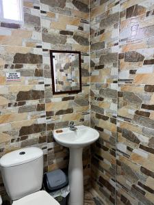 Un baño con lavabo, inodoro y espejo. en Tropical Dreams, en San Andrés