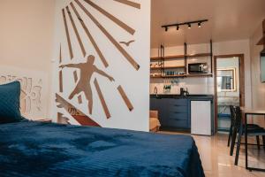a bedroom with a bed and a kitchen with a counter at LOFT Sofisticado na Praia de Vila - Centro in Saquarema +4 photos