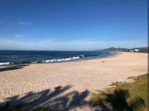 a view of a beach with the ocean in the background at LOFT Sofisticado na Praia de Vila - Centro in Saquarema