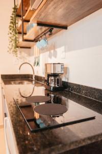 a kitchen with a counter top with a coffee maker at LOFT Sofisticado na Praia de Vila - Centro in Saquarema