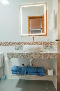 a bathroom with a sink and a mirror at LOFT Sofisticado na Praia de Vila - Centro in Saquarema +4 photos