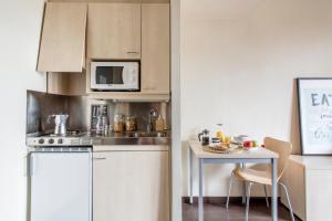 a small kitchen with a table and a microwave at Residencia Universitaria Giner de Los Ríos in Alcalá de Henares