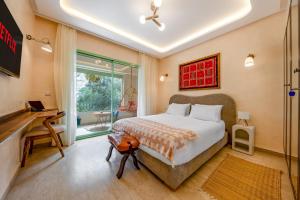 a bedroom with a bed and a desk and a window at Babylone Appart & Pool, Hivernage in Marrakech +26 photos