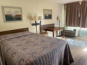 a hotel room with a bed and a desk at Tyler Inn & Suites in Tyler