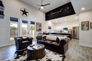 a living room with two leather couches and a kitchen at The Outlaw Lake House Canyon Lake FAMILY in Spring Branch