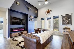 a living room with a leather couch and a tv at The Outlaw Lake House Canyon Lake FAMILY in Spring Branch