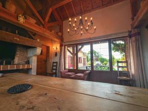 a dining room with a large wooden table and a chandelier at Maison de charme en Berry près d'un golf & spa, jardin d'hiver, vélos, animaux bienvenus - tout inclus - FR-1-591-332 in Pouligny-Notre-Dame