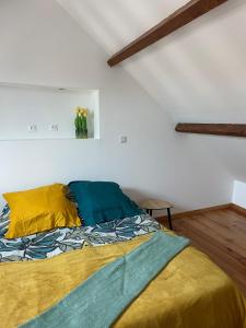 Schlafzimmer mit einem Bett mit gelber und grüner Bettwäsche in der Unterkunft HSH France Nid de Chambry proche Disneyland in Chambry