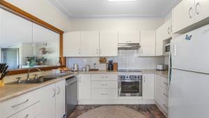 a white kitchen with white cabinets and a sink at Margarets Place - Character Filled Cottage In Heart Of Gloucester in Gloucester +9 photos