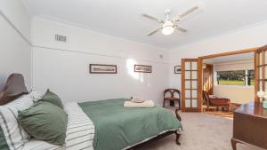 ein Schlafzimmer mit einem Bett und einem Deckenventilator in der Unterkunft Margarets Place - Character Filled Cottage In Heart Of Gloucester in Gloucester + 13 Fotos