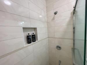 a bathroom with a shower with two shampoo bottles at Near JFK-Private room with share bath and Kitchen in Brooklyn