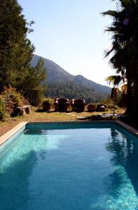 a blue swimming pool with a view of a mountain at Casa del Paso in Bolulla